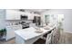 Bright kitchen boasts white cabinets, marble countertops, stainless appliances, and island seating at 1794 Daystar Dr, Haines City, FL 33844