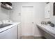 Clean laundry room features a white washer and dryer, shelving, and a marbled countertop at 1794 Daystar Dr, Haines City, FL 33844