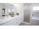 Elegant main bathroom with double vanity, marble countertops, and a glass-enclosed shower at 1794 Daystar Dr, Haines City, FL 33844