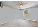 Bright bedroom features neutral carpet, ceiling fan and single window with view of outdoors at 2020 Indian Trl, Lakeland, FL 33813