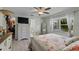 Bedroom featuring a ceiling fan, a floral print bedspread, and a view into the ensuite bathroom at 2020 Indian Trl, Lakeland, FL 33813