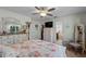 Bedroom featuring a ceiling fan, a floral print bedspread, and a view into the ensuite bathroom at 2020 Indian Trl, Lakeland, FL 33813