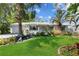 Charming single-story home featuring lush landscaping, vibrant green lawn, and decorative flower beds at 2020 Indian Trl, Lakeland, FL 33813