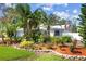 Landscaped front yard showcasing colorful foliage, mature trees, and decorative elements at 2020 Indian Trl, Lakeland, FL 33813