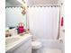 Bathroom with white cabinets, toilet, and bathtub, as well as a mirror and shower curtain at 2126 Sandy Hook, Lakeland, FL 33813