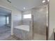 Bathroom featuring a soaking tub, separate shower, and view into carpeted bedroom at 236 Talladega Ln, Polk City, FL 33868