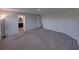 This bedroom has carpeted floors and neutrally painted walls with an open bathroom doorway at 236 Talladega Ln, Polk City, FL 33868