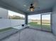 Covered outdoor patio with ceiling fan, table, and screen door overlooking manicured backyard and providing a relaxing retreat at 236 Talladega Ln, Polk City, FL 33868