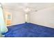 Primary bedroom with plush blue carpet, a ceiling fan, and adjacent bathroom and closet at 2613 Sundance Cir, Mulberry, FL 33860