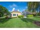 Home's exterior with large screened-in lanai, lush green grass and shrubbery at 2900 Grasslands Dr, Lakeland, FL 33803