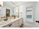 Bathroom featuring double sinks, travertine countertops, and a shuttered window at 2900 Grasslands Dr, Lakeland, FL 33803