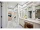 Bathroom with double sinks, decorative wallpaper, and a hallway that leads to the bedroom and pool at 2900 Grasslands Dr, Lakeland, FL 33803