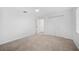 Bedroom featuring neutral carpet, white walls, closet and door leading to other room at 2900 Grasslands Dr, Lakeland, FL 33803