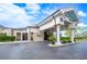 Elegant clubhouse entrance with a covered drop-off area, stone accents, and well-maintained landscaping at 2900 Grasslands Dr, Lakeland, FL 33803