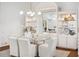 Elegant dining room features modern chandelier, built-in glass shelving, and seating for six at 2900 Grasslands Dr, Lakeland, FL 33803
