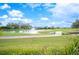 Scenic view of the golf course with a pond and water fountain feature on a sunny day at 2900 Grasslands Dr, Lakeland, FL 33803