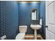 Charming half-bathroom with blue wallpaper, pedestal sink, and dark bronze fixtures at 2900 Grasslands Dr, Lakeland, FL 33803