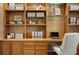 Cozy home office featuring built-in wooden shelves, cabinets, and a sleek, modern desk setup at 2900 Grasslands Dr, Lakeland, FL 33803