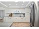 Bright and modern kitchen with white cabinetry, tile backsplash, and stainless steel refrigerator at 2900 Grasslands Dr, Lakeland, FL 33803
