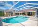 Beautiful screened-in pool with attached hot tub and a travertine patio at 2900 Grasslands Dr, Lakeland, FL 33803