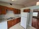 Functional kitchen with wood cabinets, granite countertops, white appliances and stainless steel sink at 320 Eron Way # 6, Winter Garden, FL 34787