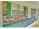 An exterior elevation of a red brick home with green trim and white windows at 3995 Townley Dr, Mulberry, FL 33860