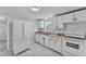 Traditional kitchen featuring white appliances, cabinets, and tile floors at 3995 Townley Dr, Mulberry, FL 33860