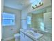 Bathroom with a single sink vanity, granite countertop, and a window, and open door at 4062 Tullamore Ln, Auburndale, FL 33823