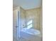Bathroom bathtub with light beige tile surround and shower head at 4062 Tullamore Ln, Auburndale, FL 33823