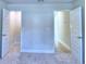 A bright bedroom with neutral walls and carpet with two open doors at 4062 Tullamore Ln, Auburndale, FL 33823