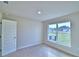 Well-lit bedroom with plush carpeting and a large window overlooking the backyard and bringing in natural light at 4062 Tullamore Ln, Auburndale, FL 33823