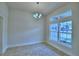 Elegant dining room with modern chandelier, large windows, and neutral tile flooring at 4062 Tullamore Ln, Auburndale, FL 33823