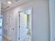 Hallway view with multiple doors, including one leading to the bathroom with a tub at 4062 Tullamore Ln, Auburndale, FL 33823