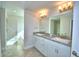 Bathroom featuring dual sinks, white cabinets, granite countertop, and tile flooring at 4123 Tullamore Ln, Auburndale, FL 33823