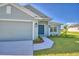 Charming home with a covered entryway, featuring lush landscaping and a well-maintained two-car garage at 4123 Tullamore Ln, Auburndale, FL 33823