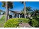 Rear exterior view of a home with a screened-in patio and tropical landscaping at 4315 Larrys Lagoon, Winter Haven, FL 33884