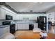 Well-lit kitchen with white cabinets, laminate countertops, and black appliances with view of dining area at 4315 Larrys Lagoon, Winter Haven, FL 33884