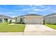 Charming single-story home featuring a well-manicured lawn, a two-car garage, and lush landscaping at 4424 Reding Way, Lakeland, FL 33813