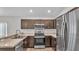 A modern kitchen with stainless steel appliances, granite countertops, and dark brown cabinetry at 4424 Reding Way, Lakeland, FL 33813