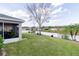 Large backyard with a pristine lawn, framed by a white fence and lush greenery, offering a serene outdoor space at 4427 Whistlewood Cir, Lakeland, FL 33811