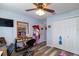 Bedroom featuring wood-look floors, a ceiling fan, a wall-mounted TV and a large closet at 4427 Whistlewood Cir, Lakeland, FL 33811