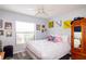 Bedroom boasting natural light, a cozy bed, charming decor, and wood-look flooring at 4427 Whistlewood Cir, Lakeland, FL 33811