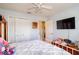 Bedroom with a ceiling fan, a wall-mounted TV, closet space and an open doorway to another room at 4427 Whistlewood Cir, Lakeland, FL 33811