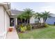 Exterior showcasing the landscaped front yard with vibrant plants and decorative palm trees at 4427 Whistlewood Cir, Lakeland, FL 33811