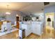 Bright open floor plan featuring kitchen island, white cabinetry, and stainless steel appliances at 4427 Whistlewood Cir, Lakeland, FL 33811