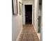 Inviting hallway with hardwood floors, decorative rug, and framed artwork leading to bright, open rooms at 4641 Devon Ave, Lakeland, FL 33813