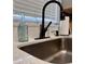 Close-up of kitchen sink, faucet, and accessories, complemented by natural light from the window at 4641 Devon Ave, Lakeland, FL 33813