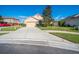 Pleasant single-story home with a well-kept lawn and a concrete driveway on a sunny day at 474 Cedar Glen Dr, Lake Alfred, FL 33850