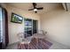 Enclosed patio offers a cozy spot with comfortable seating, ceiling fan, and a view of the outdoors at 474 Cedar Glen Dr, Lake Alfred, FL 33850