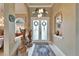 Elegant foyer featuring double doors, tile flooring, high ceilings, and decorative art pieces at 565 Osprey Landing Dr, Lakeland, FL 33813